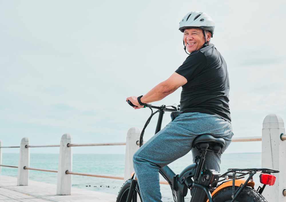  travel with a senior man on a promenade, riding eco friendly transport by the beach. Sustainability, cycling 