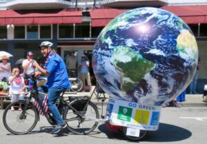 man on ebike towing a globe of the earth