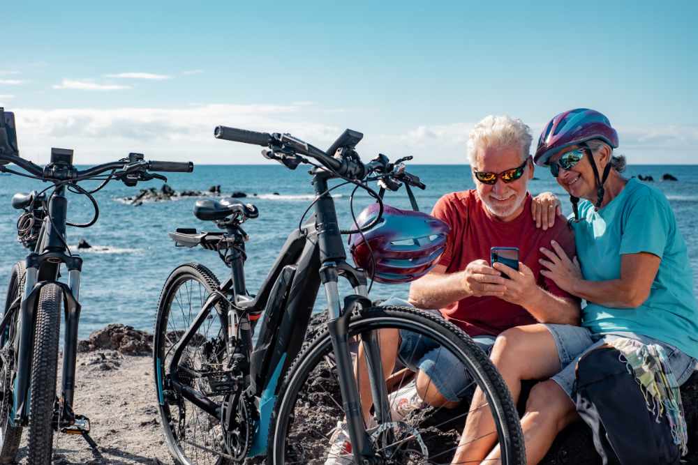 Couple having a break from riding their e-bikes next to the sea